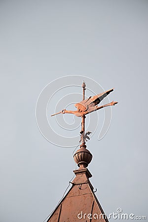 Vertical shot of a weathervane on a tower of a building Stock Photo