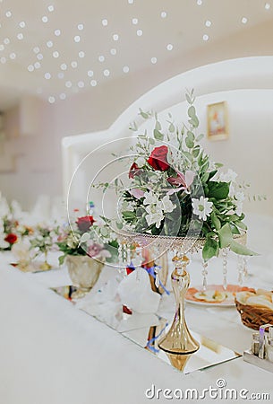 Vertical shot of wedding table decorations with beautiful floral compositions Stock Photo