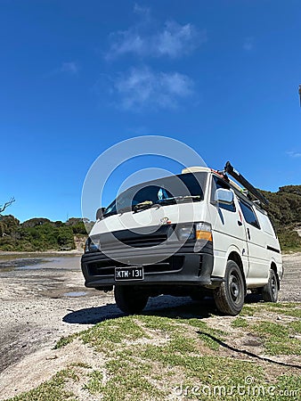 Vertical shot of a white Toyota Hiace Van off-road on sand dune on a blue background Editorial Stock Photo