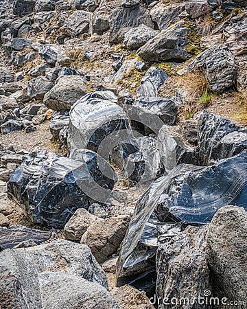 Vertical shot of wild black shining rocks Stock Photo