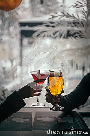 Vertical shot of a woman and man with glasses of cocktail and beer Stock Photo