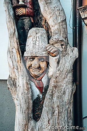 Vertical shot of wood carving, a funny gnom in a tree Stock Photo