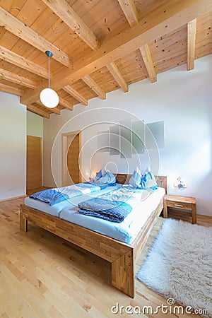 Vertical shot of wooden bed in bedroom Stock Photo