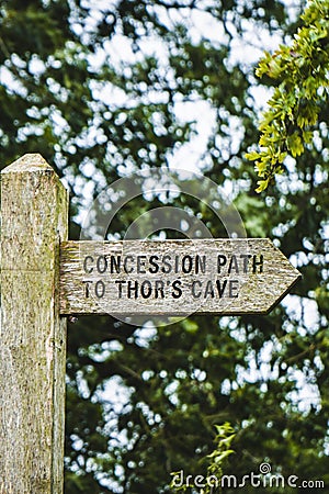 Vertical shot of a wooden "concession path to Thor's cave" sign in England Stock Photo