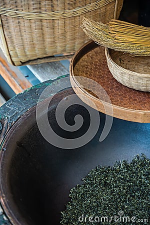 Vertical shot of woven baskets, broom and dried tea leaves in a bowl Stock Photo