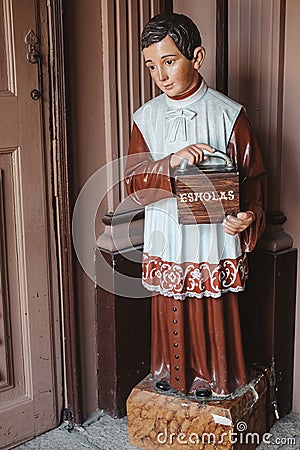 Vertical shot of a young boy statue symbolizing the act of almsgiving and virtue Stock Photo