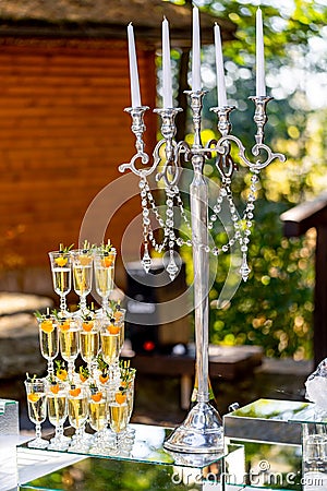 Vertical stand of champagne in the glasses. Candelstick with pearl thread. Nice tender decoration Stock Photo