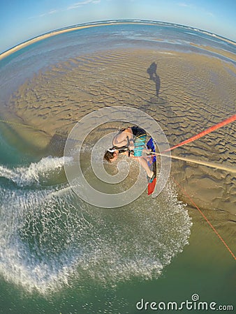 VERTICAL: Stunning view from the kite of a kiteboarder jumping high in the air. Stock Photo