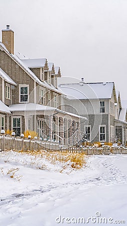 Vertical Trail impressed on snow covered ground along houses during winter season Stock Photo