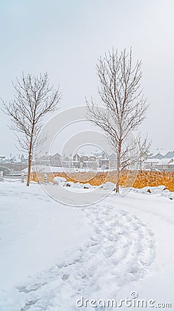 Vertical Trail on the powdery snow along Oquirrh Lake with view of homes and vast sky Stock Photo