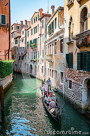 Vertical Venice picture with a canal and tourists on a gondola Editorial Stock Photo