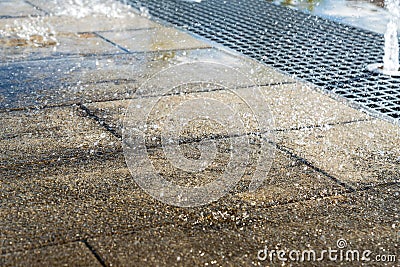 Vertical water streams of dry fountain, close up view. Streams flowing out of stainless grate Stock Photo