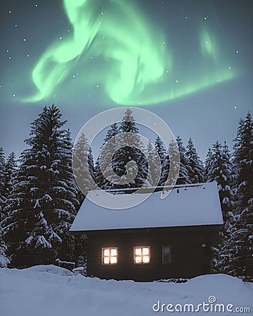 Vertical of wooden hut in a snowy forest in Beskydy mountains, Czech Republic under Aurora borealis Stock Photo