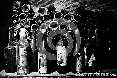 Very ancient bottles of wine lies in retro dark cellar Stock Photo