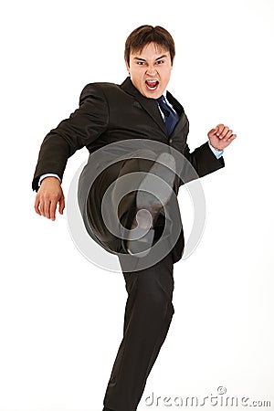 Very angry young businessman hard kicking isolated Stock Photo