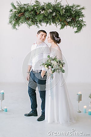Very beautiful wedding of amazing couple. Wedding ceremony in light white room decorated with flowers and candles. Stock Photo