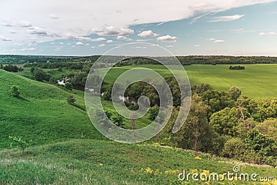Colorful Bright Sunny Green Field Landscape With Blue Cloudy Sky, River Trees And Hills Stock Photo