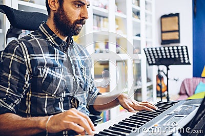 Very concentrated pianist practices with his piano in his home studio Stock Photo