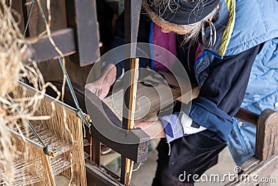 A very elderly undefined Hmong woman works on an ancient loom Stock Photo