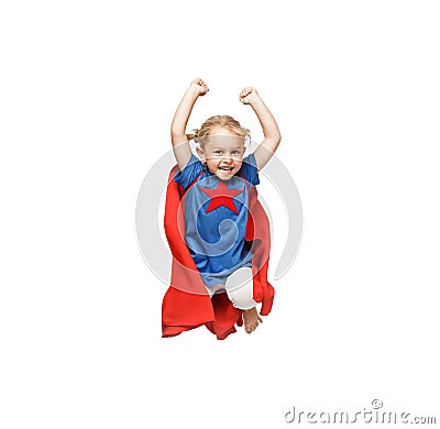 Very excited little girl dressed like hero jumping isolated on white background. Stock Photo