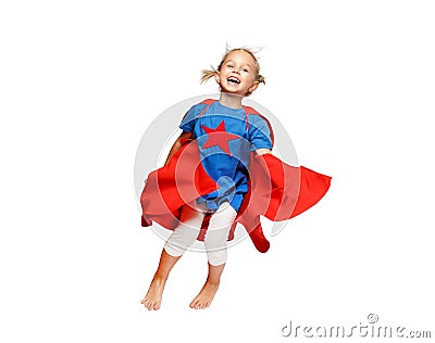 Very excited little girl dressed like hero jumping isolated on white background. Stock Photo