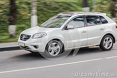 Very fast dangerous driving car on road. white car moves fast on the highway. Side view shot with long exposure motion blur effect Stock Photo