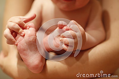 Very flexible baby biting and sucking his feet and hands Stock Photo