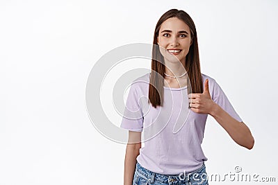 Very good, alright. Smiling happy girl shows thumb up in approval, agree and like something, excellent job, praise and Stock Photo