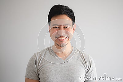 Very happy funny face of man with a big innocent smile in grey t-shirt Stock Photo