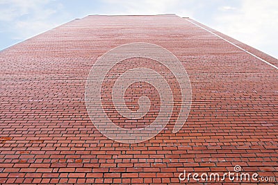 Very high wall of red brick building and cloudy sky Stock Photo