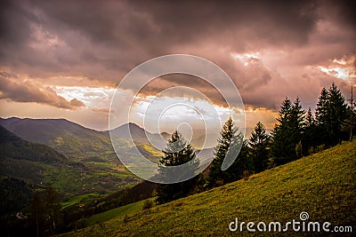 Very interesting sunset. View of spring landscapes, sunlight and dark clouds above. Stock Photo