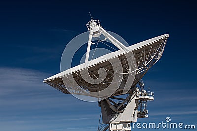 Very Large Array side view of white radio antenna satellite dish against a deep blue sky Stock Photo