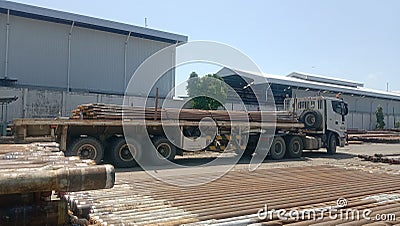 A very large field and a very long workshop and a trailer car that lifts the pipe are in the wide field Editorial Stock Photo