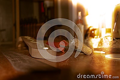 In the first light of day glittering wood glue flowing on the neck of musical instrument during the assembly of rosewood fretboard Stock Photo