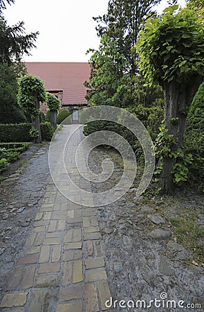 Very long stone footpath leading to an old church building Stock Photo