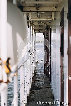 Very low ground view of a long ferry deck, with a dramatic blue, cloudy sky. Vertical Stock Photo