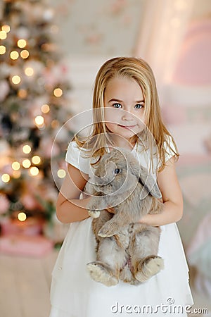 Very nice charming little girl blonde in white dress laughs and Stock Photo