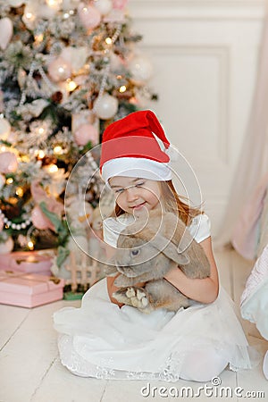 Very nice charming little girl blonde in white dress and Santa h Stock Photo
