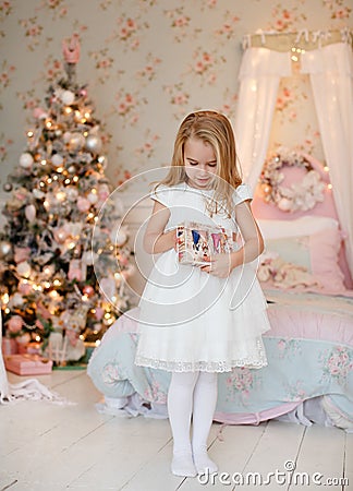 Very nice charming little girl blonde in a white dress standing Stock Photo