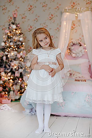 Very nice charming little girl blonde in a white dress standing Stock Photo