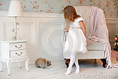 Very nice charming little girl blonde in a white dress standing Stock Photo