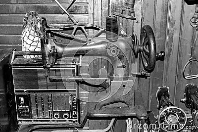 very old antique looking sewing machine and old antique radio. black and white photo. Stock Photo