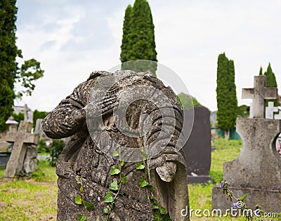 An very old broken statue of Mary old cemetery. Overgrown with ivy concept death, religion Stock Photo