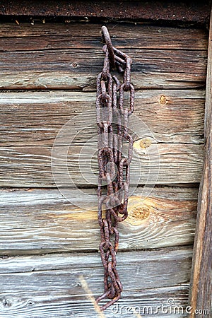 Old rosty chain on a barn wall Stock Photo