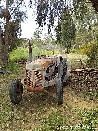 Very Old Rusty Coloured Tractor used with a saw at its rear to cut wood Editorial Stock Photo