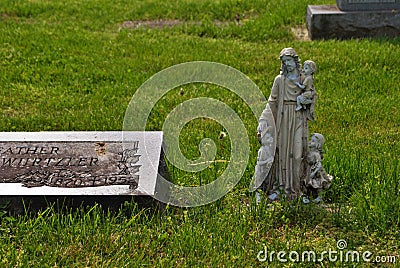 Very old statue and headstone in a cemetery Stock Photo