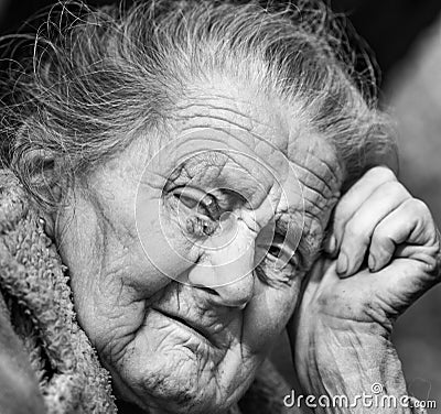 Very old and tired wrinkled woman outdoors Stock Photo