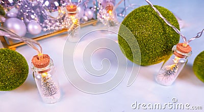 magic garland - Toy Christmas trees in glass jars and green grass balls, on a blue background. a glass casket with Stock Photo