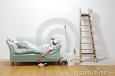 Very tired worker concept, painter man sleeps on the couch Stock Photo
