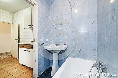Very used vintage bathroom with access to a kitchen in the same condition Stock Photo